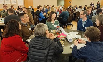 People sitting around tables talking at a recent Climate Summit.