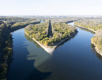 Aerial photos shows Minnesota River (left) and Mississippi River (right) joining together south of Pike Island. Minneapolis-St. Paul International Airport is in the far background.