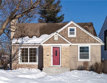 Beige starter home with snowy yard.