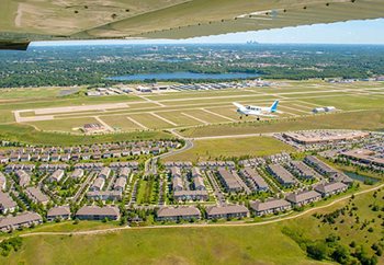 Aerial photo shows housing development in the foreground and Flying Cloud Airport in the background.