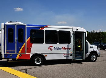 Multicolored bus with Metro Move logo on the side in parking lot.