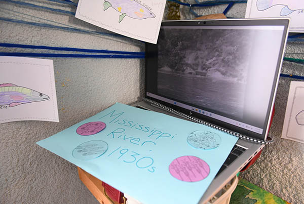 Computer laptop shows video of sewage mats floating on the Mississippi River.